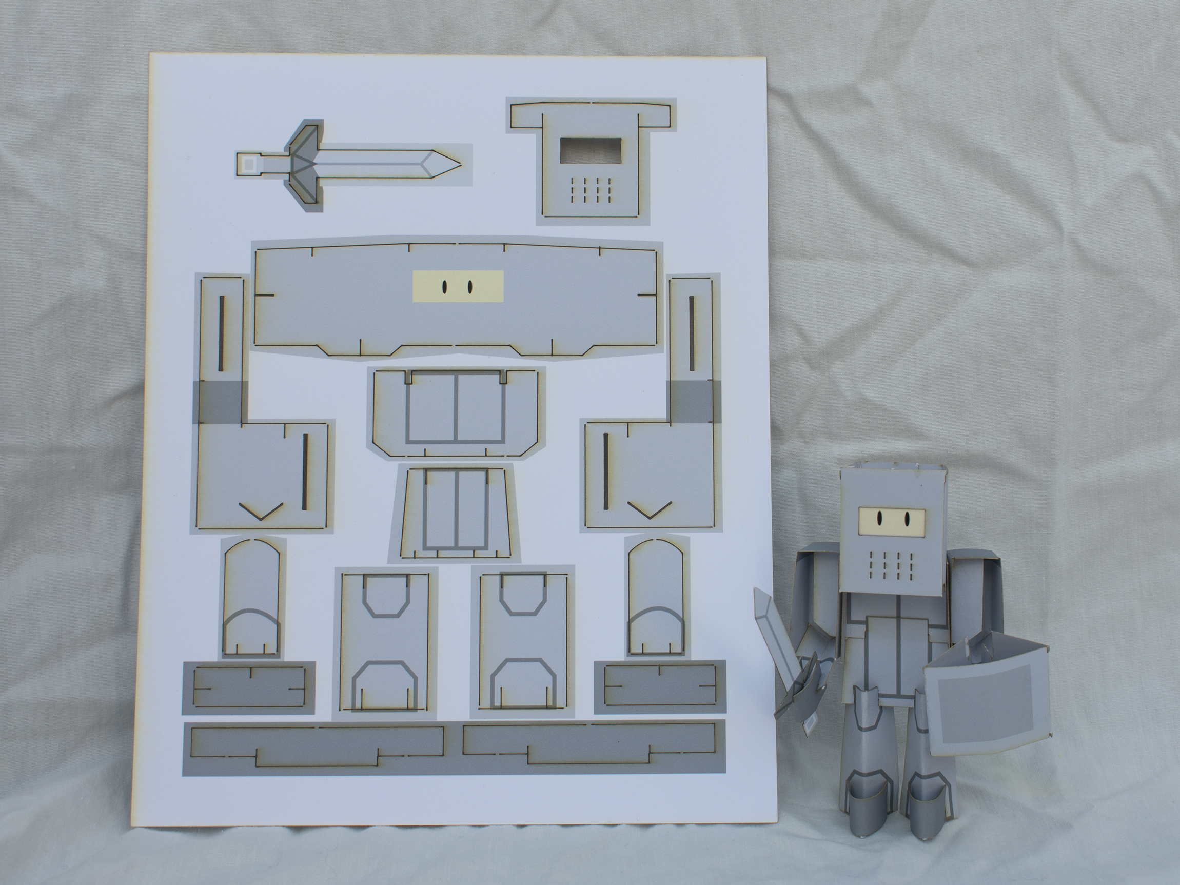 A fully assembled Sir Sodie is standing next to a unassembled sheet of him